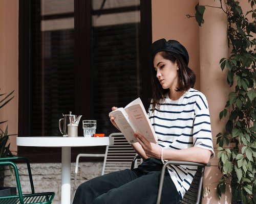 Person reading a book in a brightly lit cafe