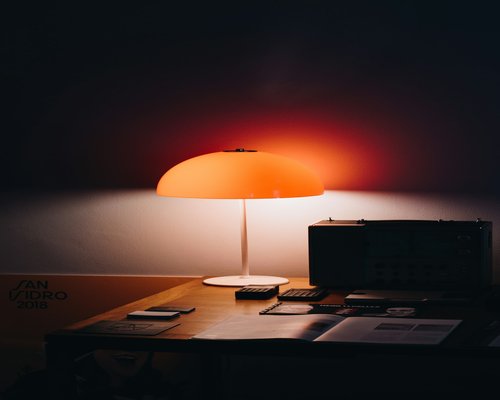 Close up of a desk lamp illuminating a notepad